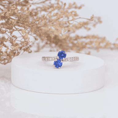 Silver ring with blue gemstones on display